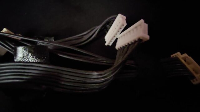 Macro Shot of Multiple Electronic Wire Connectors and Black Ribbon Cable Harness from Disassembled Device on Dark Background