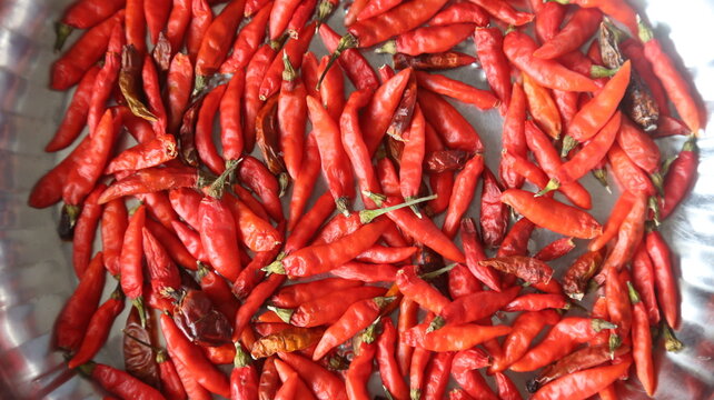 Close-up of fresh red chili peppers in a metal bowl for culinary use