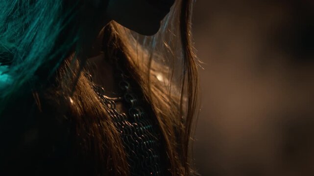 Young adult Caucasian woman wearing chainmail armor and crown looking forward as camera tilts up. Footage suits fantasy films, medieval trailers, historical storytelling, and game promotions