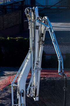 View of a white concrete pump truck arm extended at a construction site in Vilnius, Vilnius County, Lithuania.