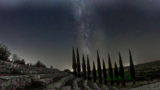 The Milky Way with trees and bleachers in the foreground