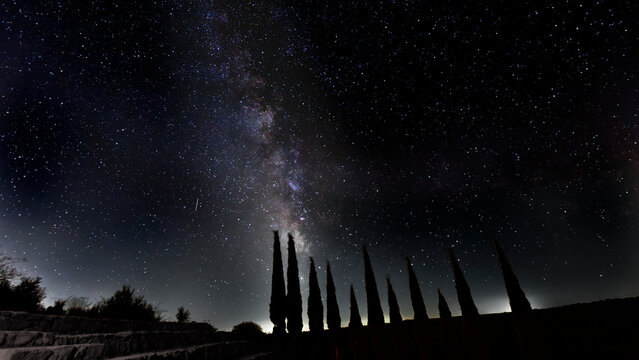 The Milky Way with trees and bleachers in the foreground