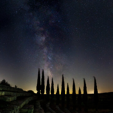 The Milky Way with trees and bleachers in the foreground
