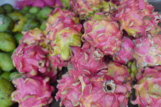 View of fresh vibrant pink dragon fruit piled up at a local market in Indonesia.