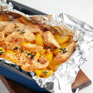 Potatoes and chicken fillets baked in foil. Easy home food