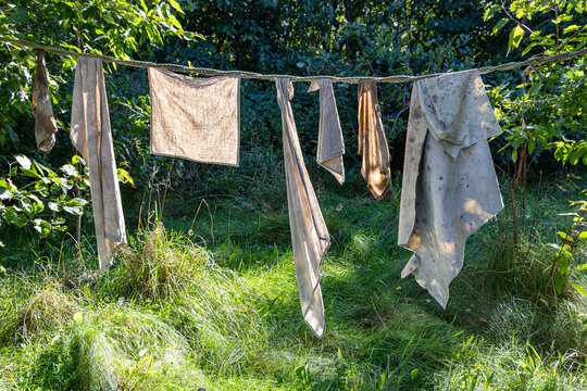 View of linen fabrics hanging on a rope line in a grassy meadow at Ribe VikingeCenter in Ribe, Jutland, Denmark.