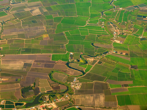 Aerial view Crop Green dry patterns farm landscape background. Land landscape vibrant agricultural fields window airplane sky summer tropical summertime on light sunny day cloudscape countryside