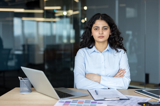 Confident Businesswoman Working At Desk With Laptop And Documents In Corporate Office. Professional Manager Planning Strategy And Analyzing Financial Analysis Reports At Her Workplace Desk.