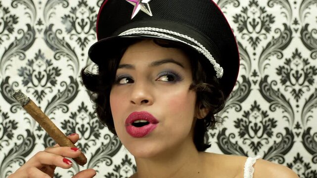 woman in lingerie smoking a cigar against vintage wallpaper