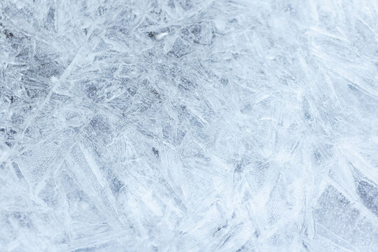 Close-up of frozen ice with intricate frosted crystal patterns creating a cold, abstract winter texture ideal for backgrounds, design projects, and seasonal themes conveying chill and purity