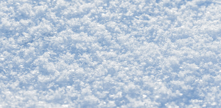 Fresh, sparkling snow blankets the ground in a close-up view, revealing delicate snowflake crystals, icy texture and soft powder perfect for winter backgrounds, seasonal projects and nature details
