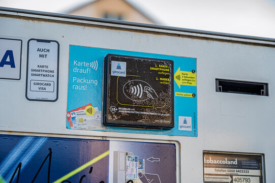 Iserlohn, Germany - July 12, 2026: Contactless payment terminal and age verification reader on an outdoor cigarette vending machine