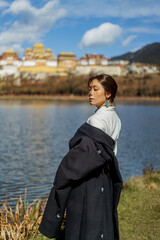 Profile portrait of woman with monastery softly blurred across the lake © nhat.photograph