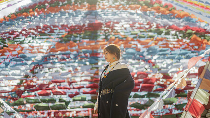 Sunlit profile portrait beneath prayer flag canopy with warm flare, Shangri-La © nhat.photograph