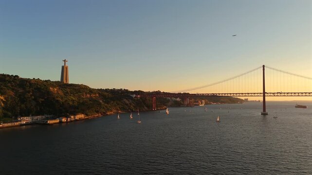 Full Length Drone Pan Across 25 de Abril Bridge With Almada Cliffs in Foreground