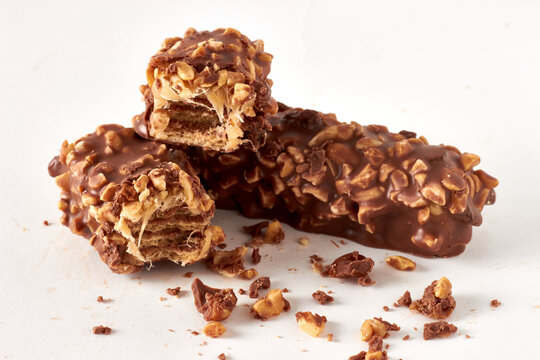 Broken Chocolate Wafer Bars with Peanuts on White Background