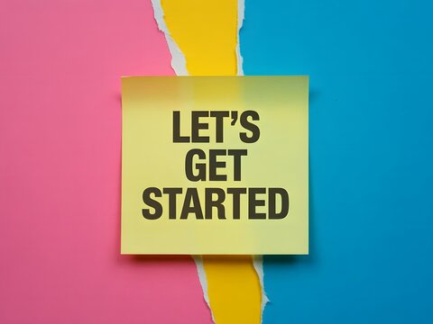 Bright yellow sticky note displaying LETS GET STARTED phrase on vivid torn pink and blue paper surface