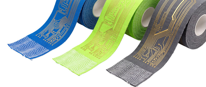 Smart kinesiology tape flexible circuit rolls featuring gold printed circuit board lines for wearable technology, bio-sensor medical devices, and sports health tracking on black studio background.