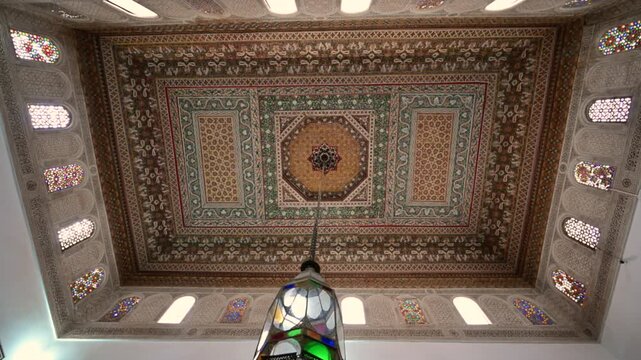 Marrakech, morocco. August 10, 2026. Majestic view of a traditional moroccan decorated ceiling with a stained glass chandelier. Intricate wooden carvings and geometric patterns