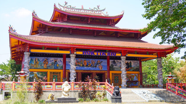 Exterior view of Hok Tik Bio Chinese temple with red roof, dragon pillars, mural, and lion statues in Blora, Central Java, Indonesia. Famous cultural heritage landmark and tourism location.