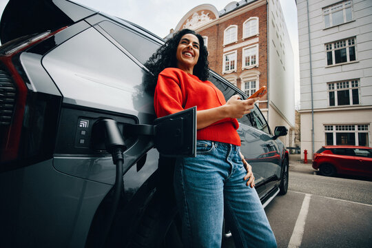 Phone use beside an electric car makes charging time feel productive