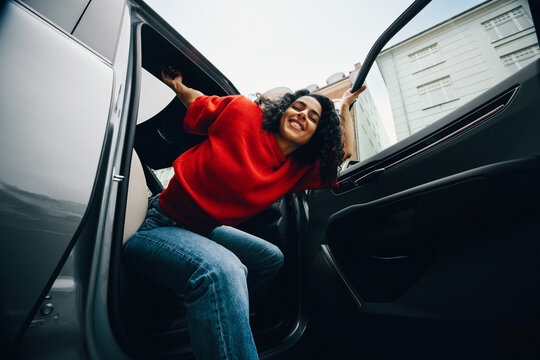 Transportation brings the woman to the city as she gets out of the car