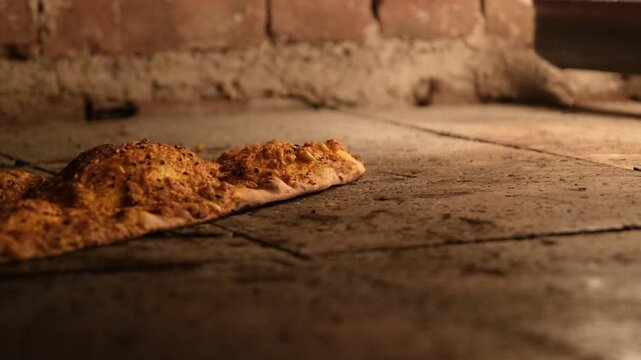 Delicious Turkish Pide, a traditional flatbread, bakes to perfection inside a hot stone oven