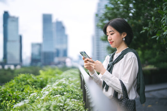 Adult entrepreneur business asian woman looking up modern lifestyles in downtown metropolis