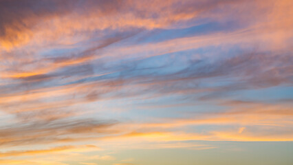 Obraz premium Wispy Sunset Clouds Over Calm Distant Horizon