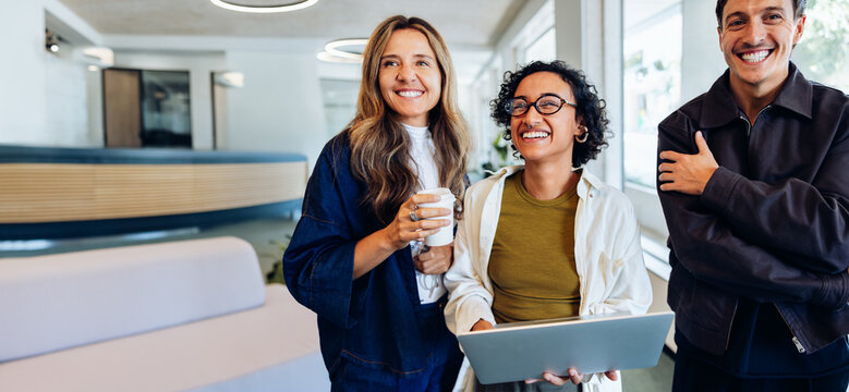 Three business professionals meet in a friendly office setting