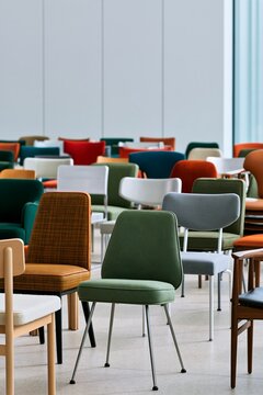 Modern colorful chairs arranged in a neat row inside a bright large hal