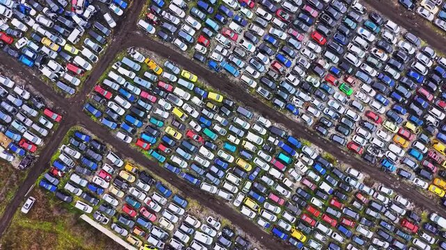 Aerial view of hundreds of cars in automotive scrapyard and recycling yard