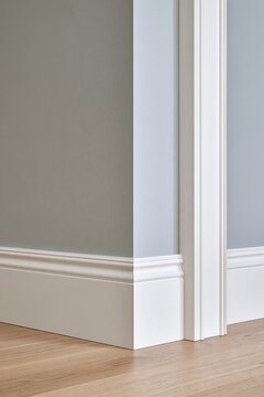 Minimalist interior corner with white baseboard trim and wood flooring