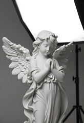 Fototapeta premium Spirituality and peace marble angel statue with praying hands for religious worship funeral memorial and divine grace in a studio lighting setup