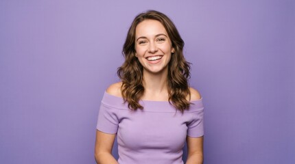 Obraz premium Happy young woman beaming brightly in front of a vibrant purple backdrop
