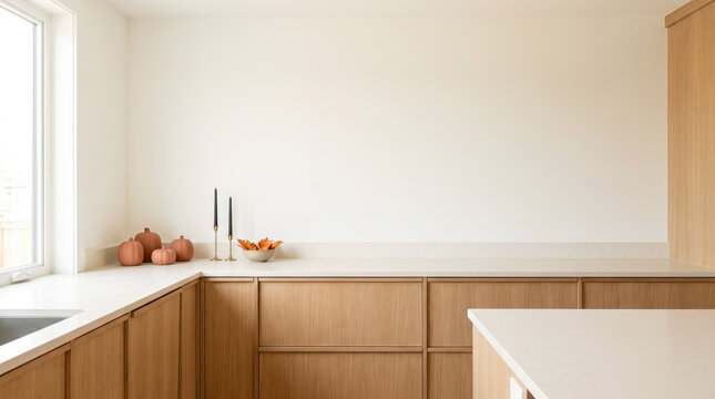 Terracotta pumpkins beside paired black candles on minimal white kitchen counter