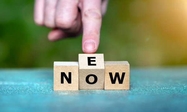 Ein Finger dreht den mittleren Buchstabenw&uuml;rfel: Aus NOW wird NEW &ndash; Symbol f&uuml;r Ver&auml;nderung, Innovation, Neustart und Zukunft.