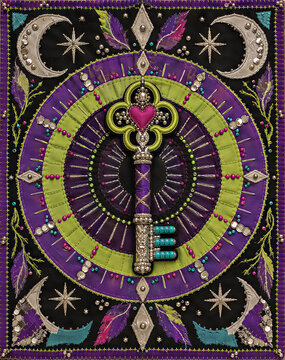 Embroidered magic key talisman with beads and sequins on purple and green fabric. Mystical textile art with moons and stars. Handcrafted esoteric tapestry