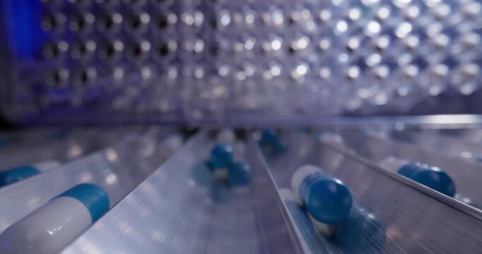 Closeup blue and white pharmaceutical capsules production line background for medical factory, probe macro view.