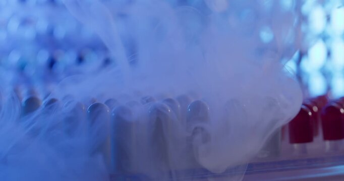 Blue gelatinous capsule with liquid nitrogen on plastic blister tray conveyor, Pharmaceutical production factory, macro view.