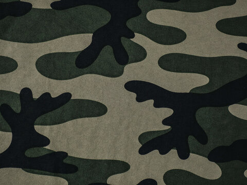 Close-up of a classic camouflage fabric pattern with green black and tan organic shapes