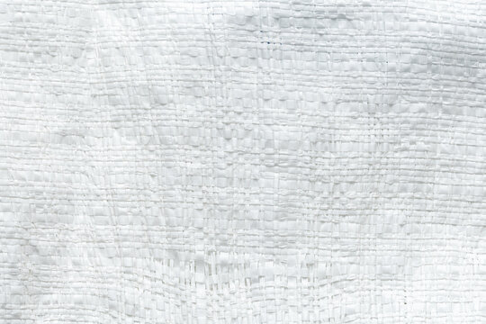 White Woven Polypropylene Plastic Sack Texture Background,Macro,A full-frame macro photograph capturing the detailed texture of a white woven polypropylene plastic sack. The interwoven synthetic.