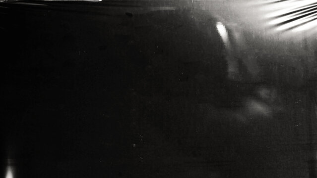 Plastic wrap texture overlay effect on black background. Shrink wrapped plastic sleeve for cover. White plastic