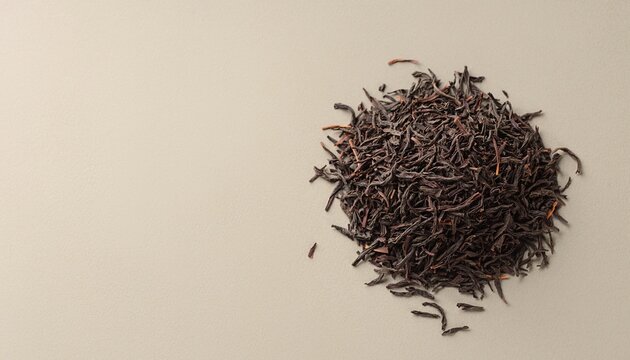 Loose black tea leaves on a neutral background with copy space