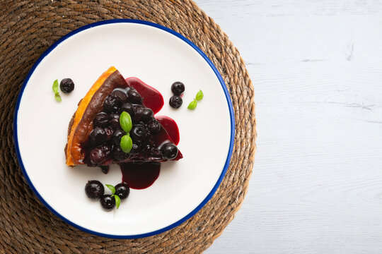 Overhead view of a slice of cheesecake with blueberry sauce.