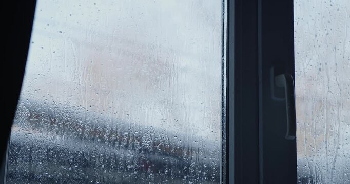 Condensation on a window, creating a dramatic and artistic atmosphere against a blurred backdrop
