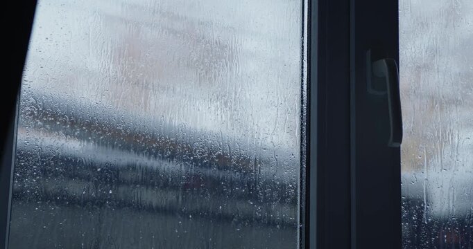 Condensation on a window, creating a dramatic and artistic atmosphere against a blurred backdrop