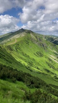 Siroka dolina and Chopok, view from Krupova hola, Nizke Tatry, Low Tatras, Slovakia. Beautfiul landscape scenery of mountains and valley. Summer with cloud sky. Panoramatic panning vertical video	