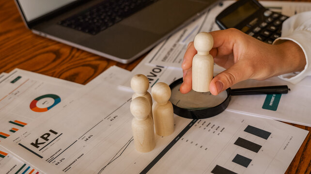 Analyzing business performance with wooden figures and financial reports