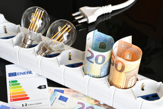 High Electricity Costs Concept with Euro Banknotes and Light Bulbs in Power Strip